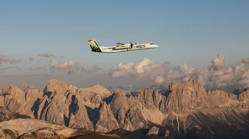 SkyAlps aircraft flying over Alpine mountain landscape
