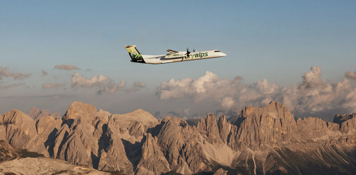 SkyAlps aircraft flying over Alpine mountain landscape