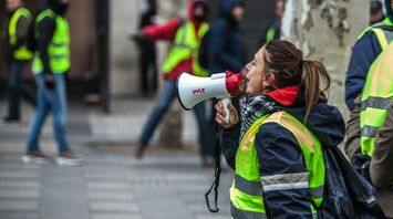 Airport workers in high-visibility vests during strike action with megaphone