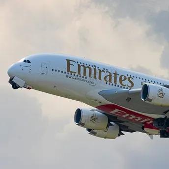 Emirates A380 aircraft flying against cloudy sky