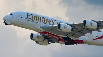 Emirates A380 aircraft flying against cloudy sky