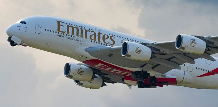 Emirates A380 aircraft flying against cloudy sky