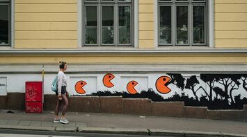 Street mural with orange figures on building wall
