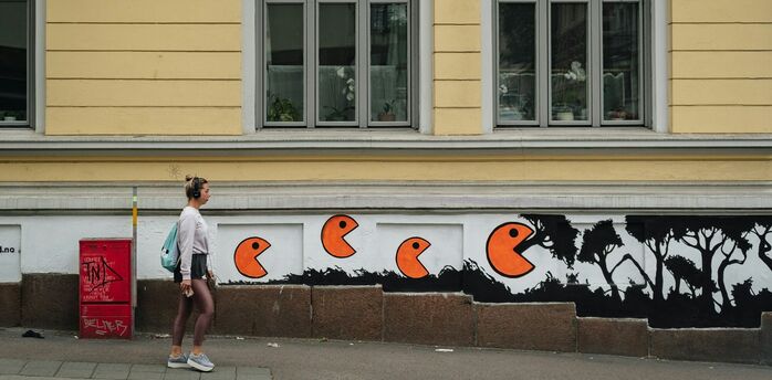 Street mural with orange figures on building wall