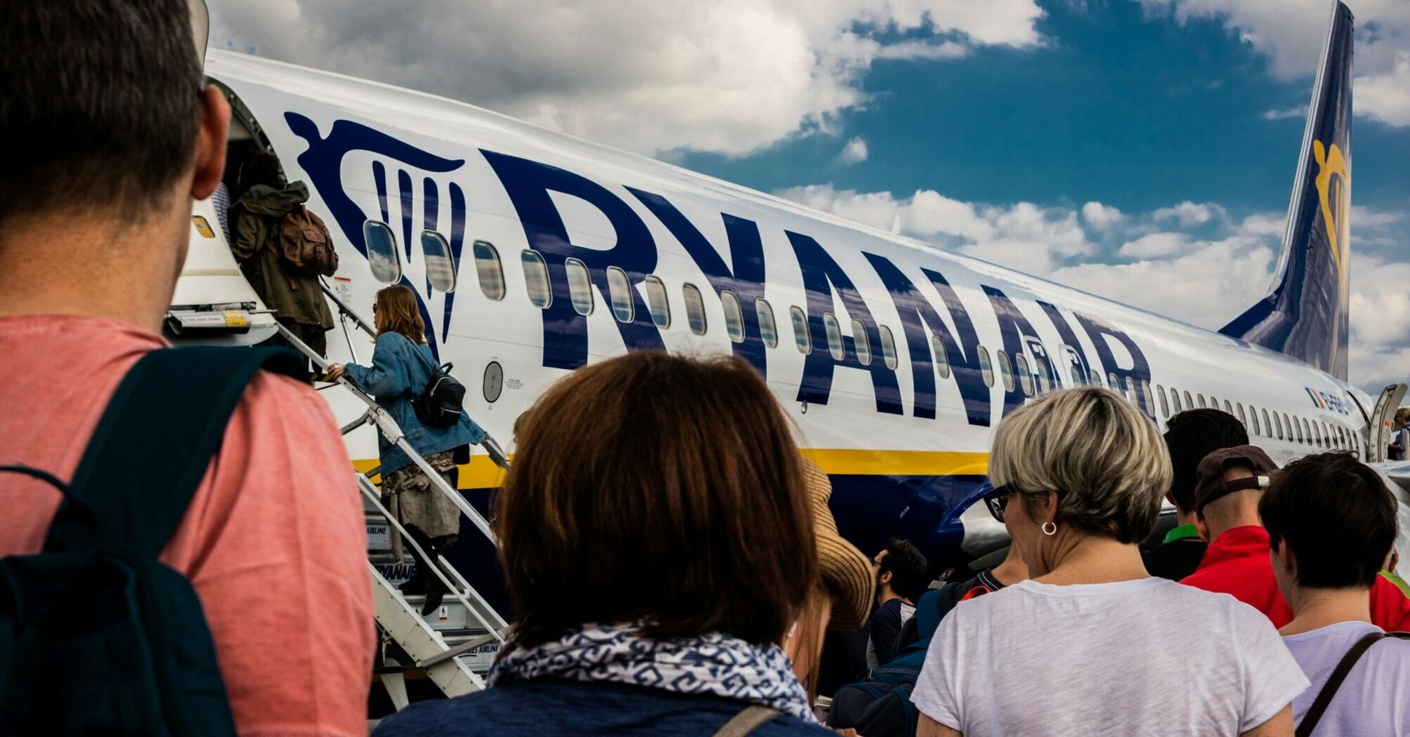 Passengers boarding a Ryanair aircraft via stairs on the apron
