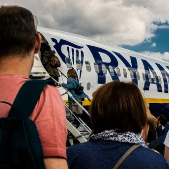 Passengers boarding a Ryanair aircraft via stairs on the apron