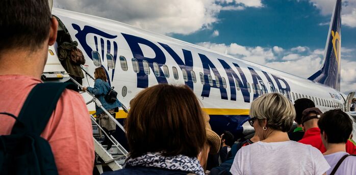 Passengers boarding a Ryanair aircraft via stairs on the apron