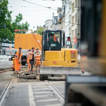 Roadworks on tram tracks with construction workers and machinery
