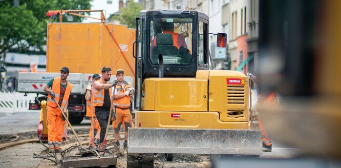 Roadworks on tram tracks with construction workers and machinery