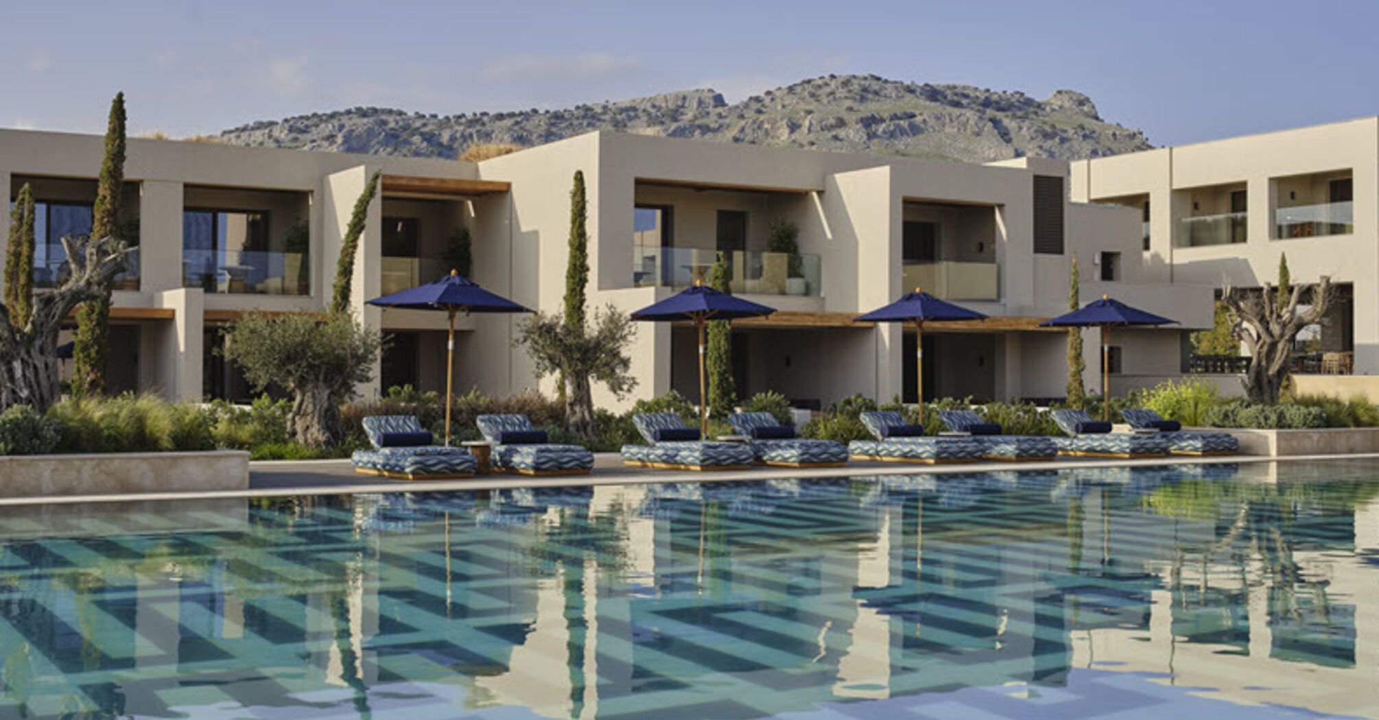 Resort buildings with pool and sun loungers in front