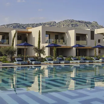 Resort buildings with pool and sun loungers in front