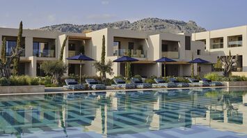 Resort buildings with pool and sun loungers in front