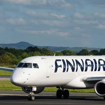 Finnair aircraft on runway with another plane taking off in the background