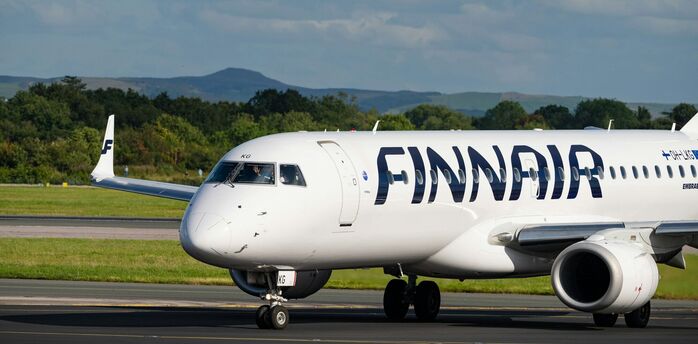 Finnair aircraft on runway with another plane taking off in the background