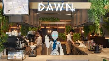Robot assistant working behind a café counter with staff preparing drinks