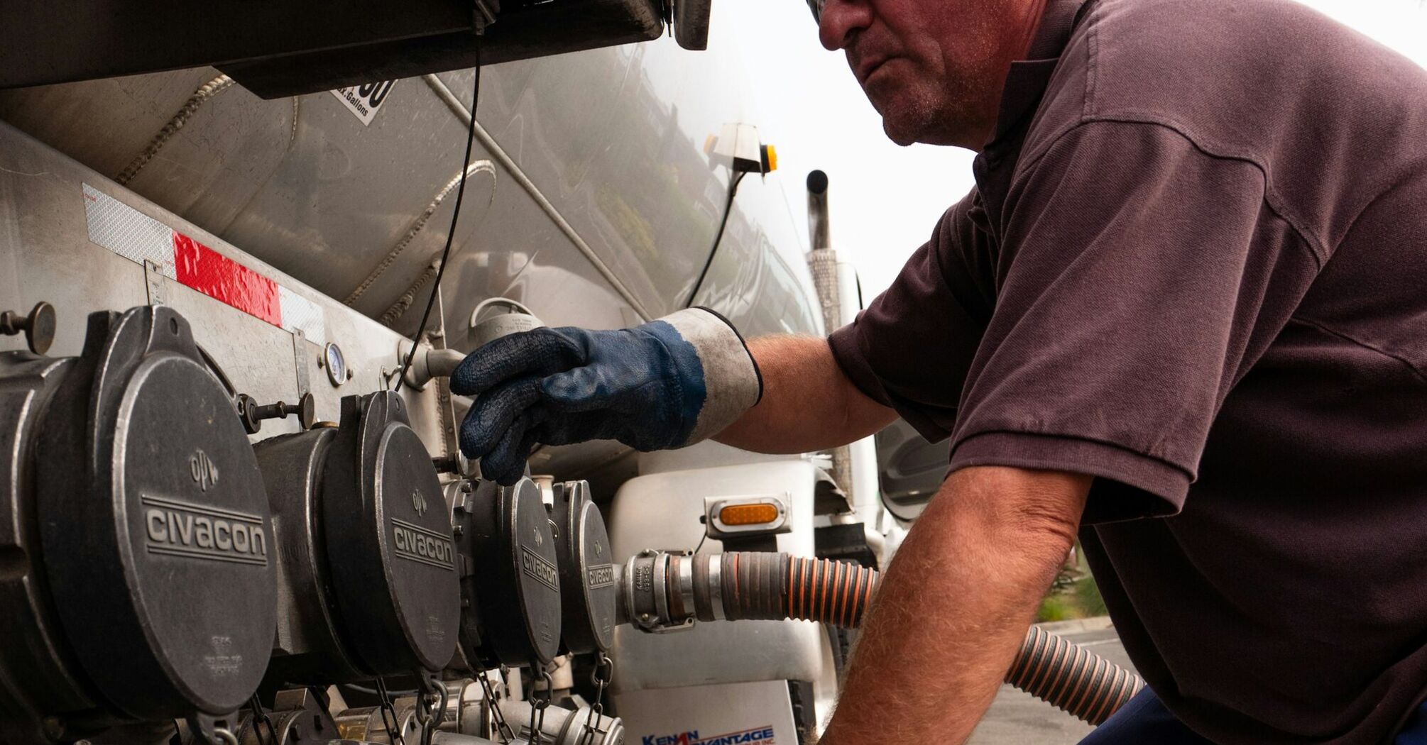 Technician connecting hose to fuel tanker