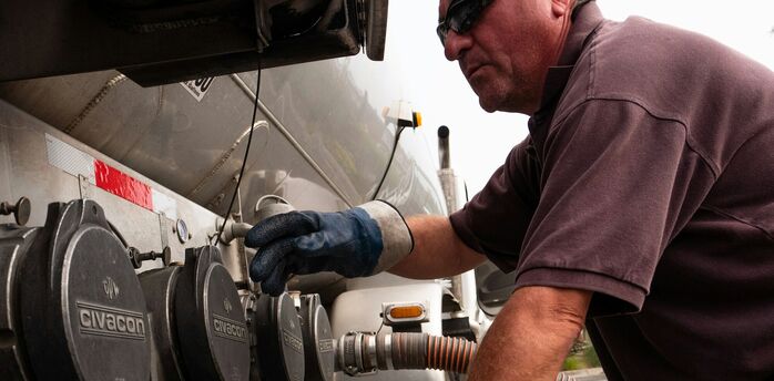 Technician connecting hose to fuel tanker