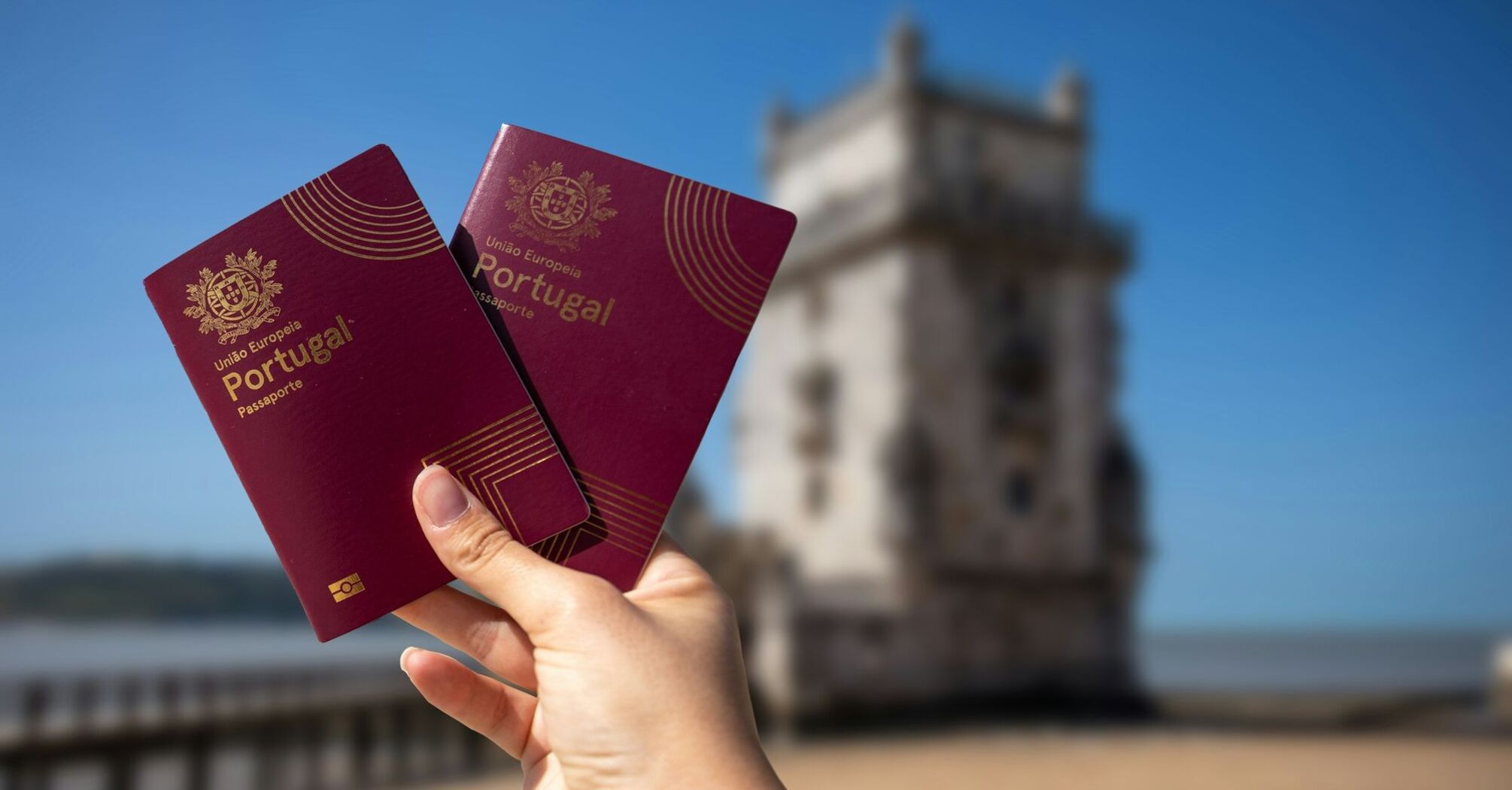 Portuguese passports held near Belém Tower in Lisbon