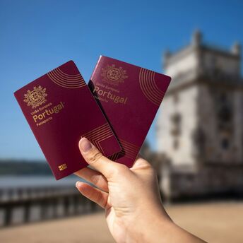 Portuguese passports held near Belém Tower in Lisbon
