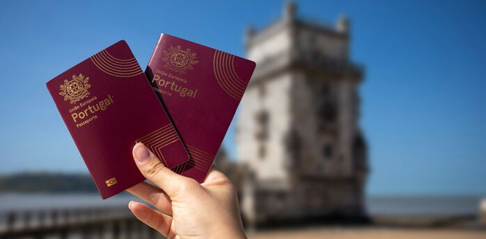 Portuguese passports held near Belém Tower in Lisbon