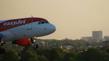 easyJet aircraft landing near a city skyline