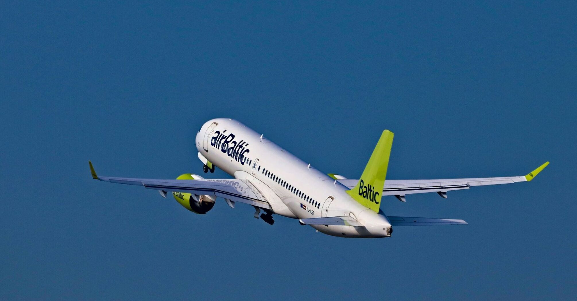 airBaltic aircraft taking off against a blue sky