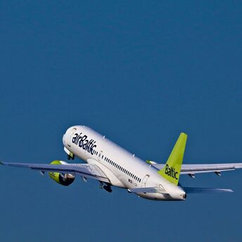 airBaltic aircraft taking off against a blue sky