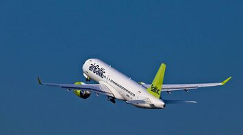 airBaltic aircraft taking off against a blue sky
