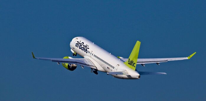 airBaltic aircraft taking off against a blue sky