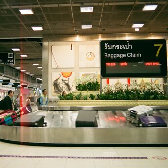 Baggage claim carousel with suitcases at an airport