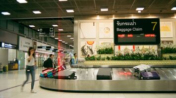 Baggage claim carousel with suitcases at an airport