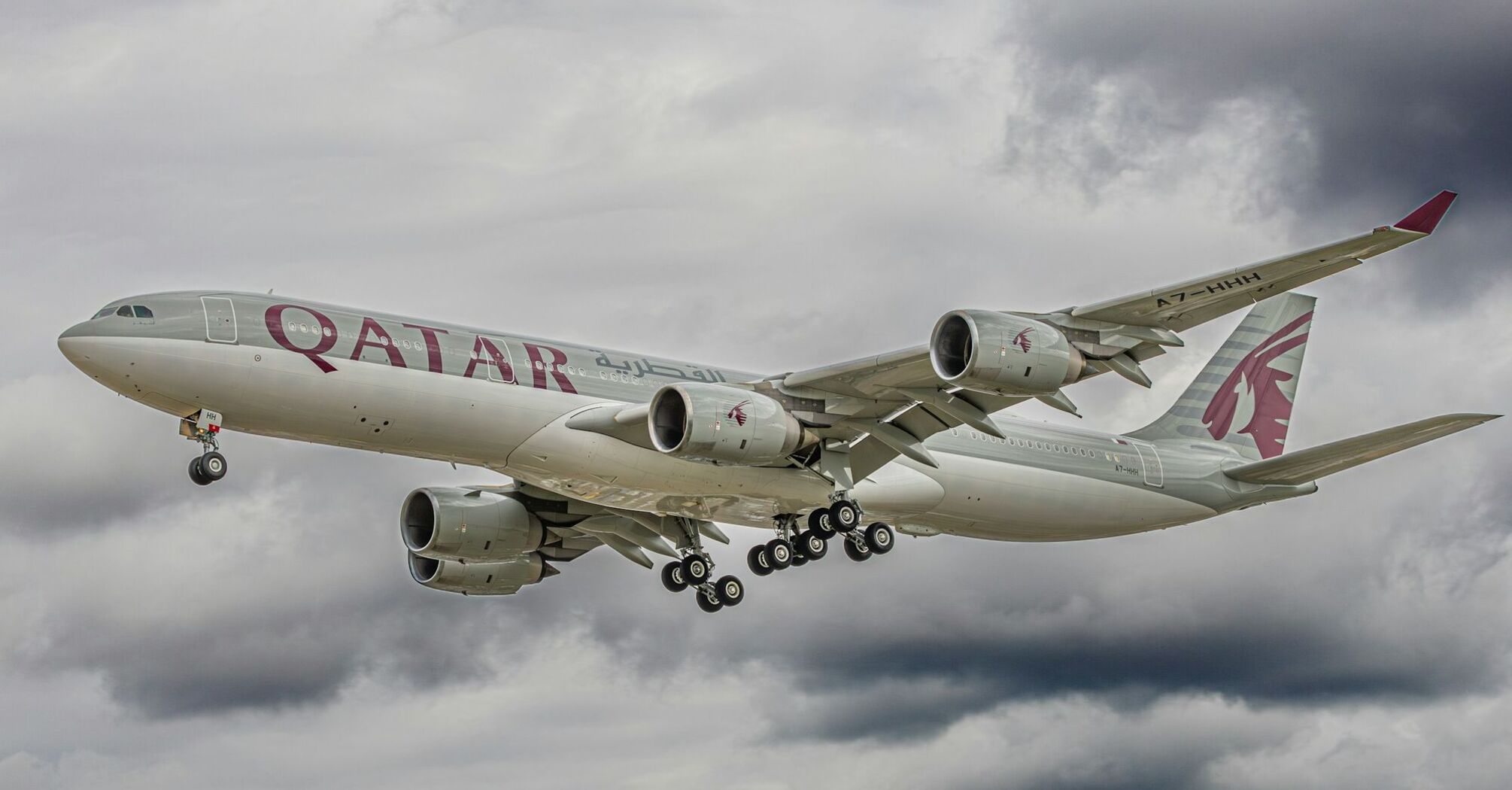 Qatar Airways aircraft flying through cloudy skies