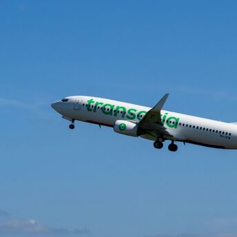 Transavia aircraft flying against a blue sky