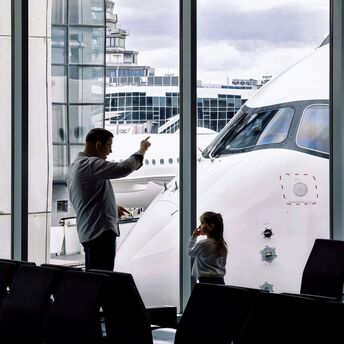 Family watching an aircraft from an airport terminal