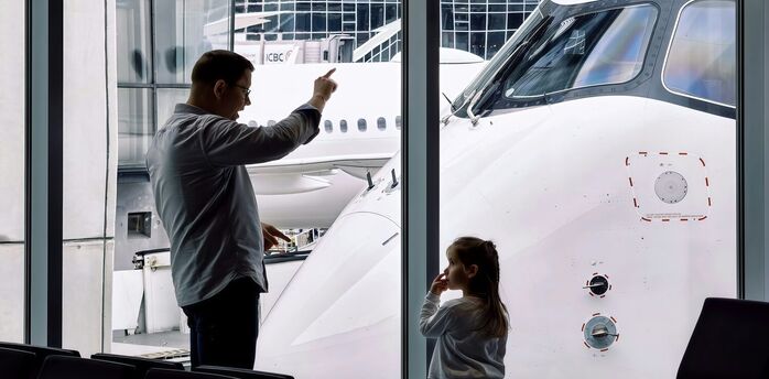 Family watching an aircraft from an airport terminal