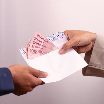 Hand giving envelope with cash