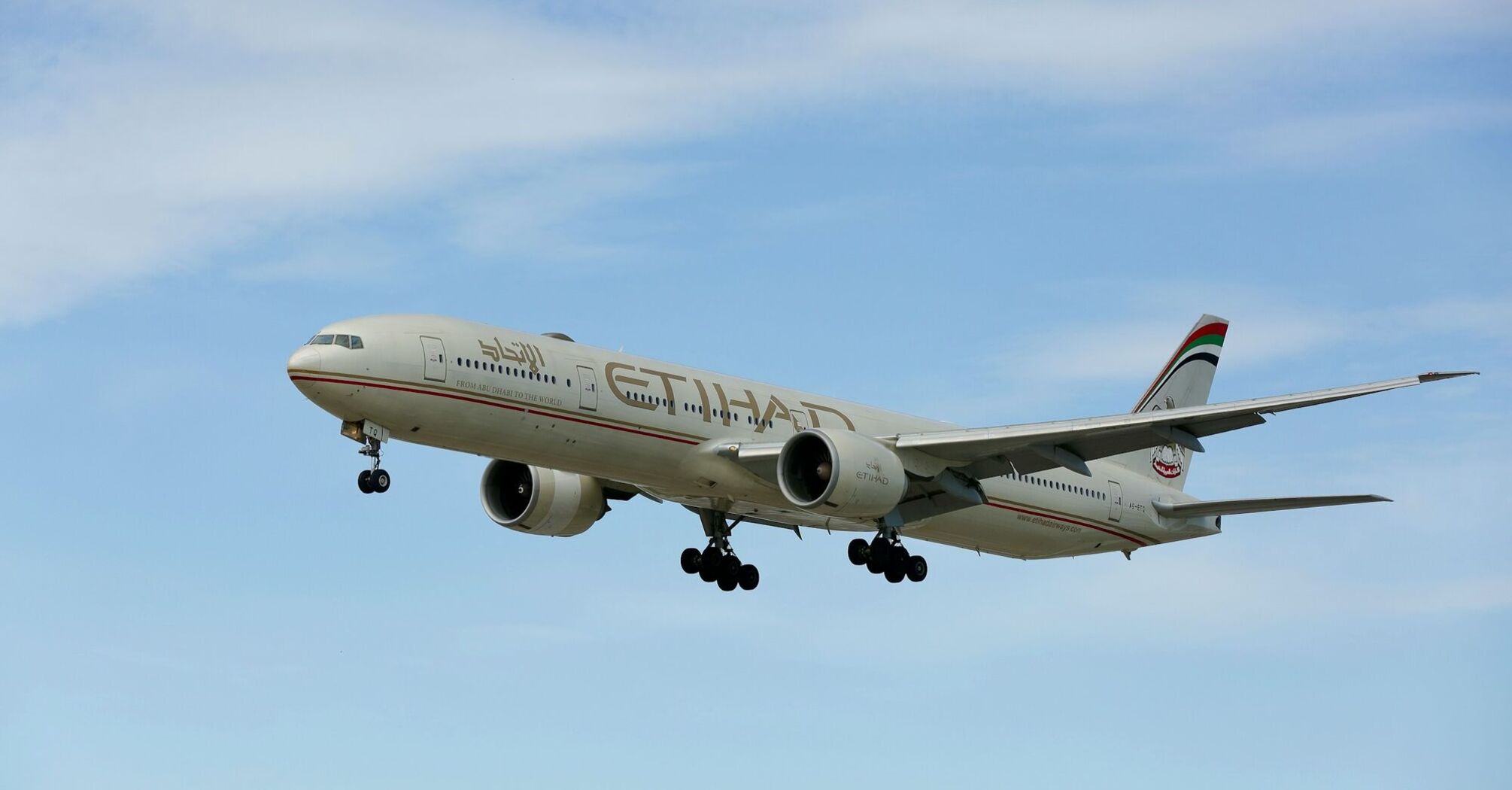 Etihad Airways aircraft flying against a blue sky
