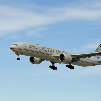 Etihad Airways aircraft flying against a blue sky