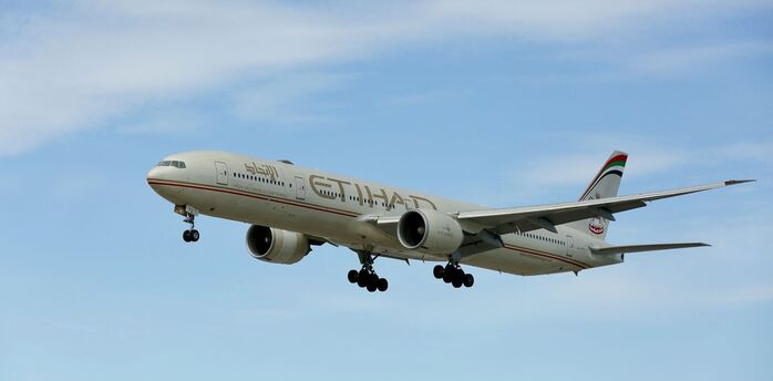 Etihad Airways aircraft flying against a blue sky