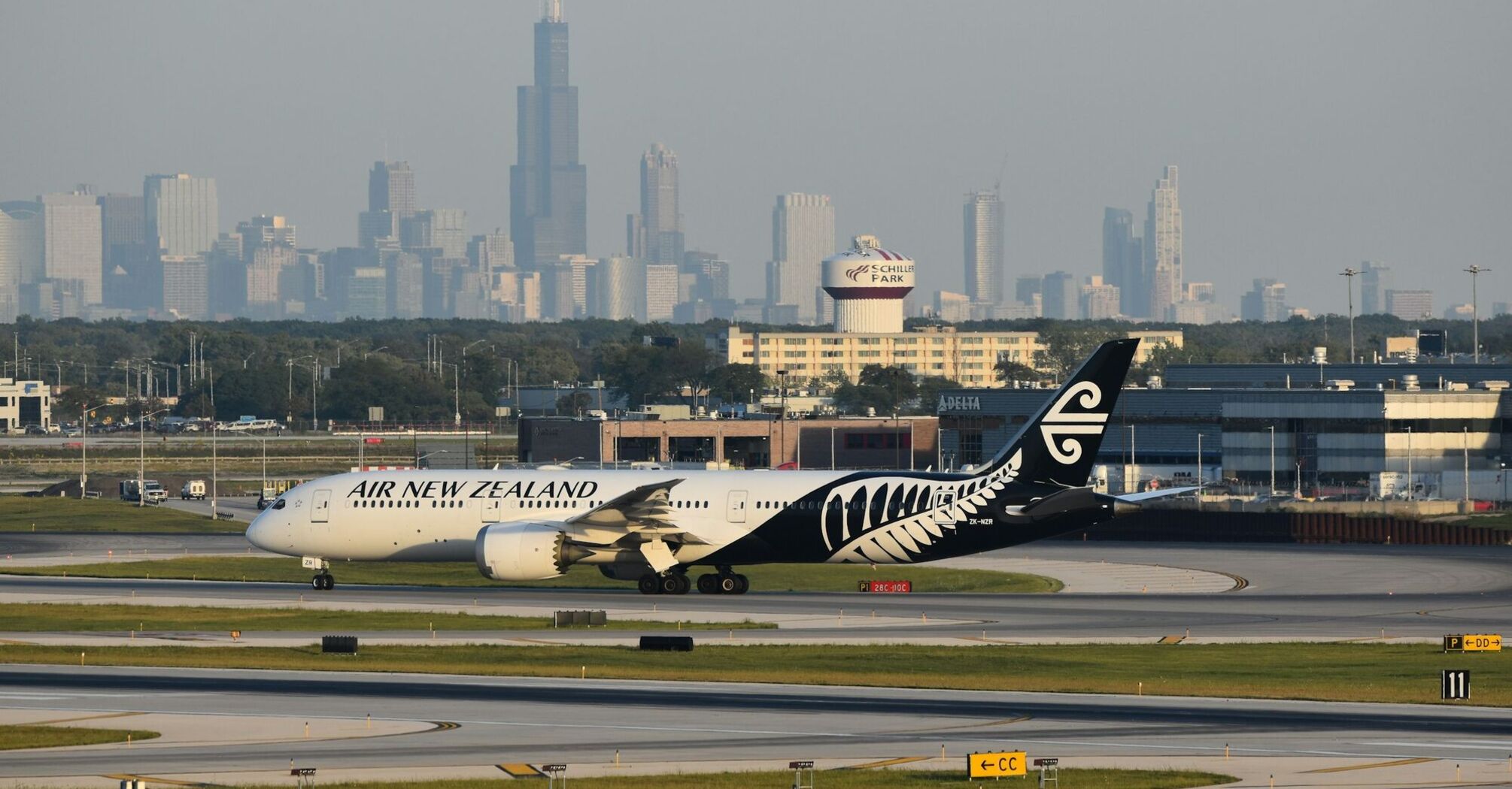 Air New Zealand aircraft on a runway with a city skyline behind it