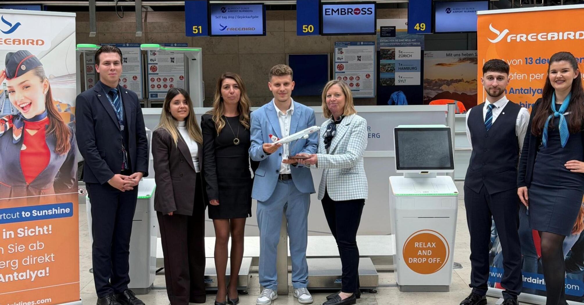 Freebird Airlines and Nuremberg Airport staff beside self bag drop counters