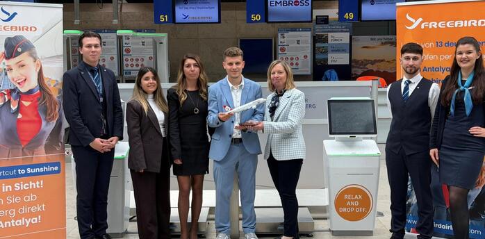 Freebird Airlines and Nuremberg Airport staff beside self bag drop counters