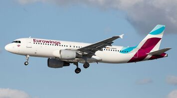 Eurowings aircraft flying through a cloudy sky