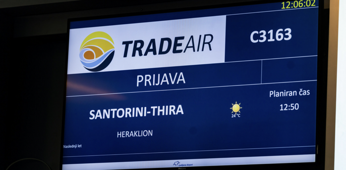 Ljubljana Airport screen showing a Trade Air flight to Santorini and Heraklion