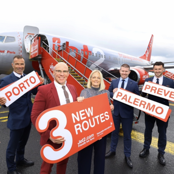 Jet2 team holding new route signs beside an aircraft