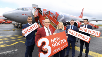 Jet2 team holding new route signs beside an aircraft