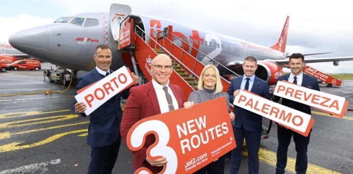 Jet2 team holding new route signs beside an aircraft
