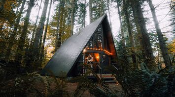 A-frame cabin in a forest listed as a holiday rental