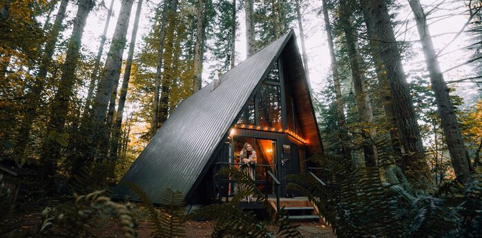 A-frame cabin in a forest listed as a holiday rental