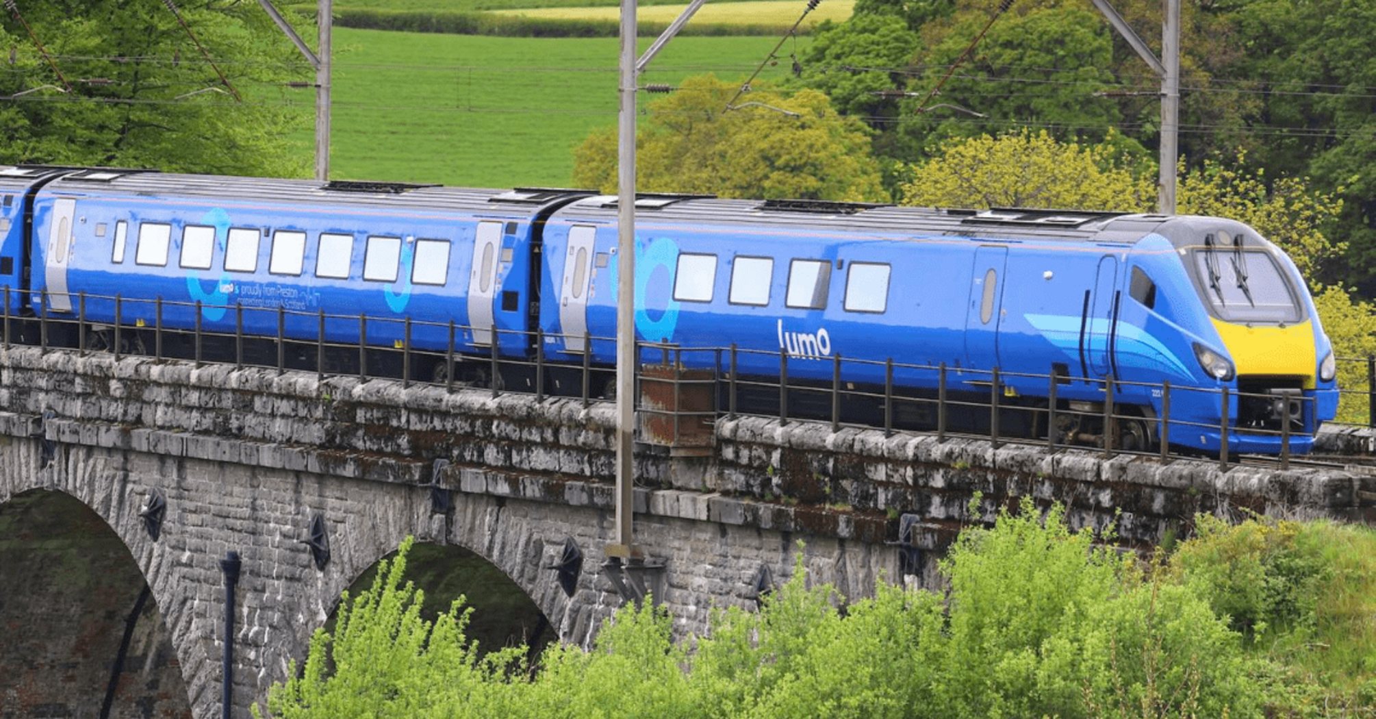 Lumo train crossing a stone railway viaduct